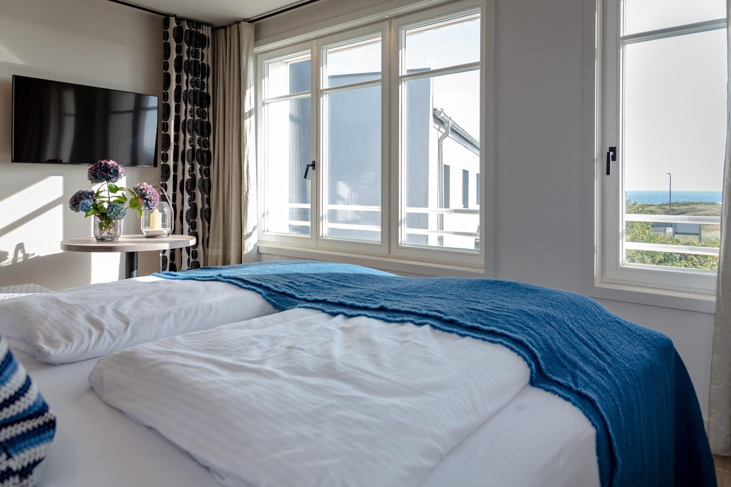 Doppelbett und Fernseher in Ferienwohnung auf Sylt