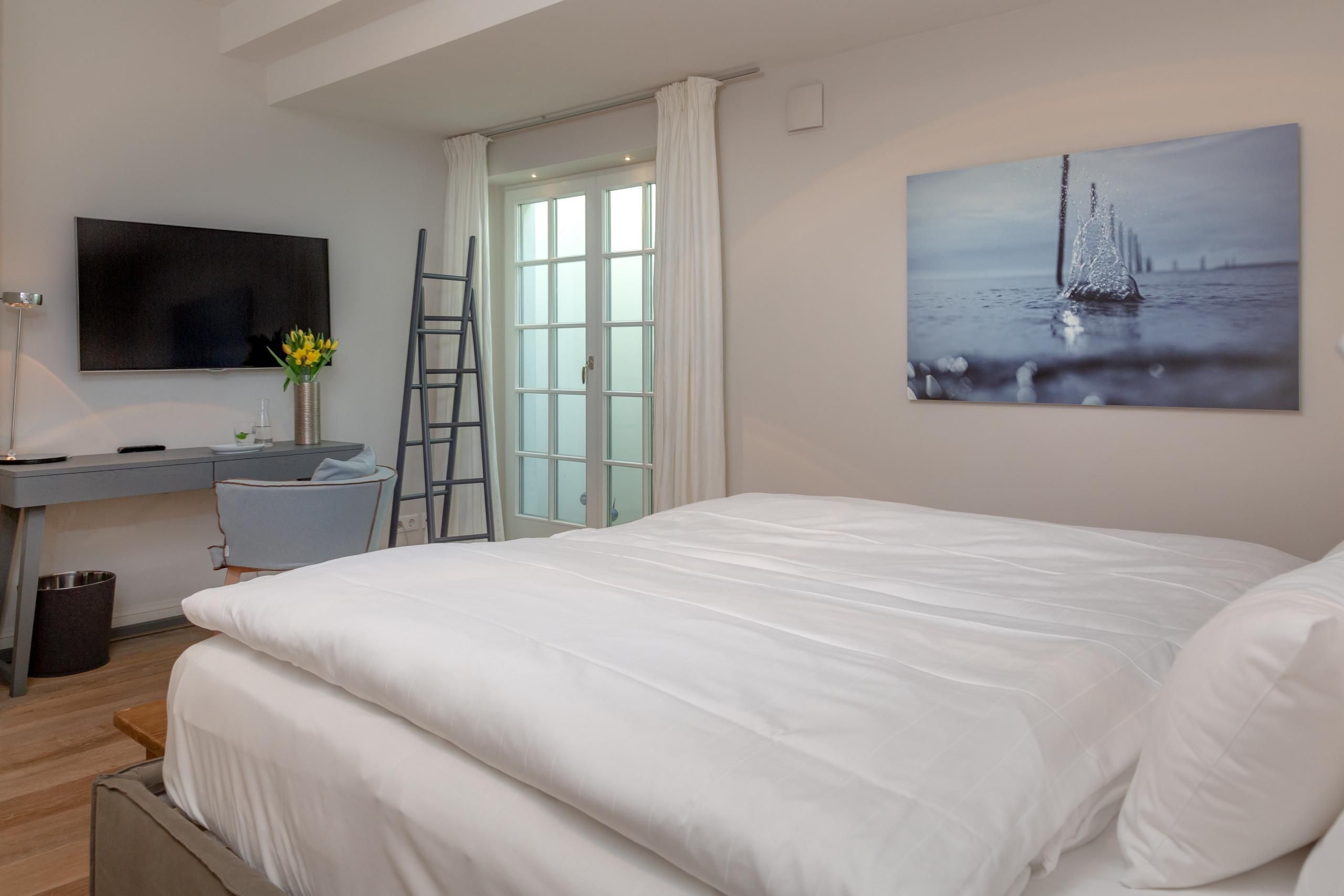 Doppelbett und Fernseher in Ferienwohnung auf Sylt