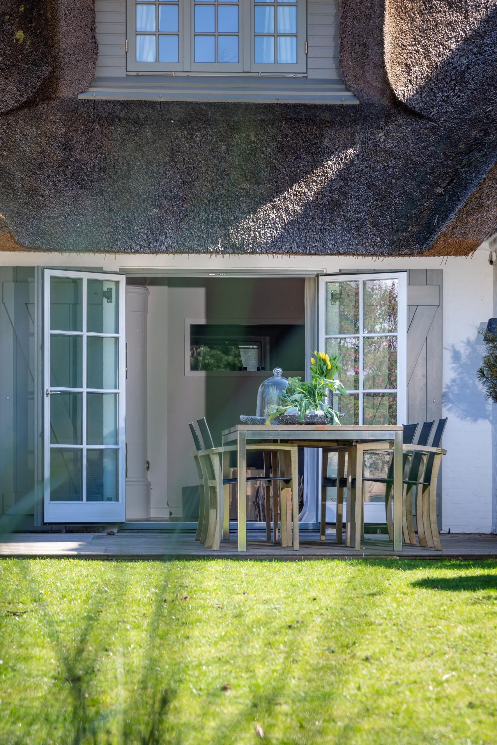 Terrasse mit Tisch und Stühlen in Ferienhaus auf Sylt